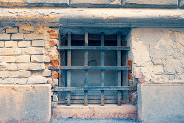 Neglected shabby brick wall with cellar window