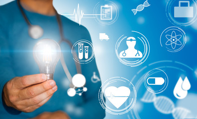 Doctor with stethoscope and light bulb in hand and medical symbols in concept of medical idea and...