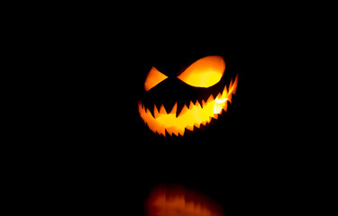 Halloween pumpkin smile and scary eyes for party night. Close up view of scary Halloween pumpkin...
