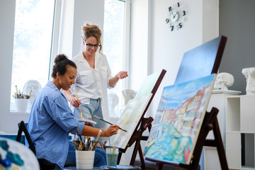 Obraz premium Creative painter and her protege working in a studio