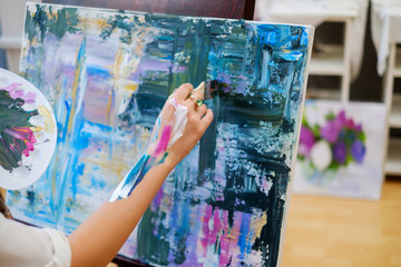 Creative painter paints a colorful picture in her studio