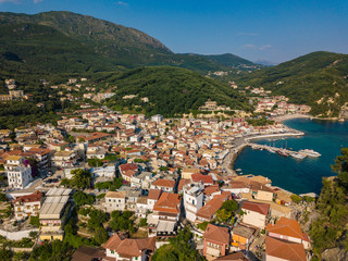 Naklejka na ściany i meble Aerial cityscape drone view of the coastal city of Parga during the summer. Beautiful architectural buildings near the port of Parga Epirus, Greece, Europe.