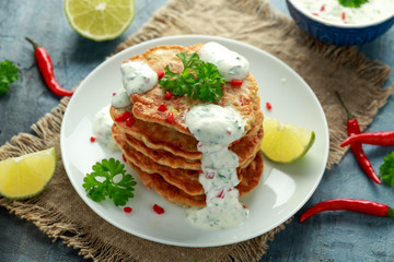 Corn fritters, pancake with dip white sauce, lime and chilli on white plate