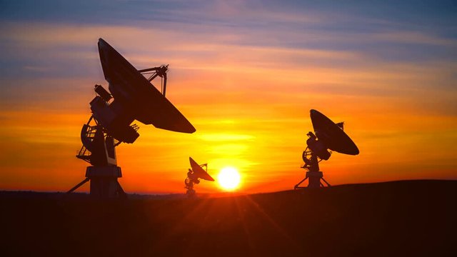 Three large radio telescope against scenic sunset sky raise its dishes up exploring evening skyt. Radio telescopes are used in science for space and distant objects in space exploration.