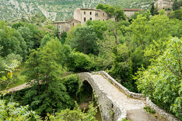 Fototapeta na wymiar An old stone bridge spans the River Vis near the village of Navacelles