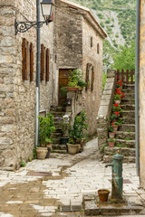 Fountain, stone flower staircase and old house in the village of Navacelles