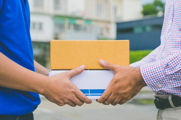 Hand accepting a delivery of boxes from deliveryman.