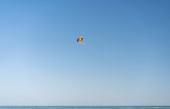 Fly with colorful parachute at the beach.