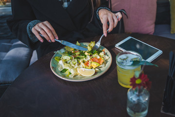 woman in cafe eating salad hands close up no face