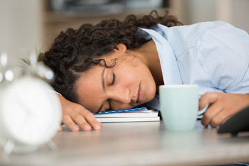 beautiful young woman sleeping on a desk at work