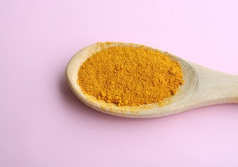 Turmeric spice powder in the wooden spoon