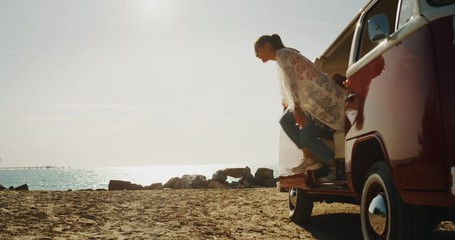 Slow motion of group of young multi-ethnic friends are arrived on a beach near the sea and having fun to go out from minivan in with a sun shining.