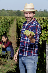 man holds white grapes