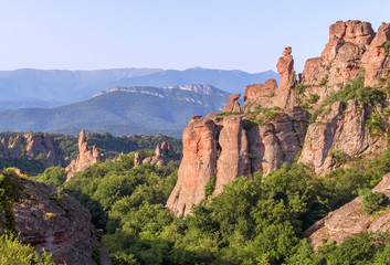 Fototapeta na wymiar Magnificent rocks among the forest at sunrise. Belogradchik, Bulgaria