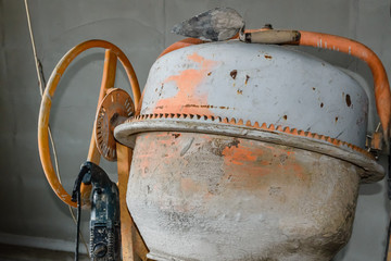 Concrete mixer and hammer drill at the construction site