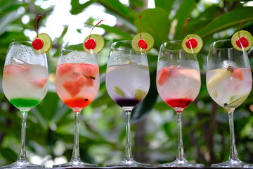glass of cocktails and flowers on background