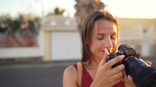 Photographer tourist woman taking photos with camera in a beautiful tropical landscape at sunset