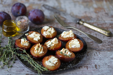 Baked plums with feta cheese. Autumn food. Keto diet. Selective focus. Macro.