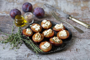 Baked plums with feta cheese. Autumn food. Keto diet. Selective focus. Macro.