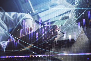 Financial forex charts displayed on woman's hand taking notes background. Concept of research. Double exposure