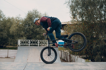 Professional young boy sportsman cyclist with bmx bike at skatepark