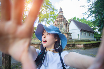 Close-up portrait of Beautiful Asian women walking to old temples and taking pictures of themselves via online media . She is a beautiful smile. Have fun and have clean teeth.