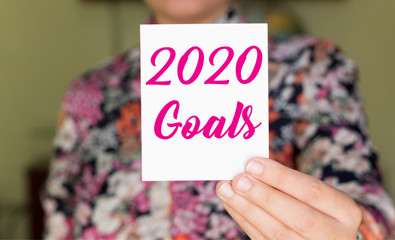 2020 goals on white card holding by businesswoman