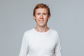 Red-haired man on a light background portrait