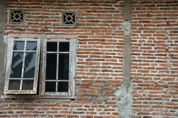 Simple traditional wooden windows on brick walls, usually found in Indonesian rural houses.