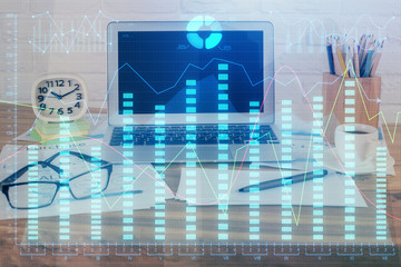 Double exposure of chart and financial info and work space with computer background. Concept of...