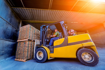 Forklift loader load lumber into a dry kiln. Wood drying in containers.