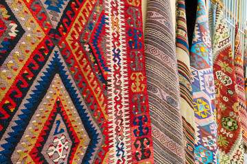 Different traditional turkish carpets hanging on a wall on a street in old town Kaleichi, Antalya, Turkey