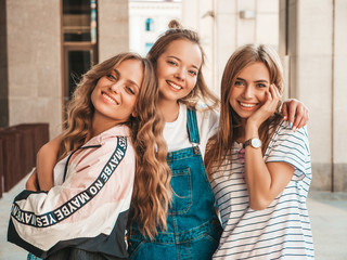 Obraz premium Portrait of three young beautiful smiling hipster girls in trendy summer clothes. Sexy carefree women posing on the street background.Positive models having fun