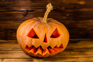 Carved halloween pumpkin jack-o-lantern on a wooden background