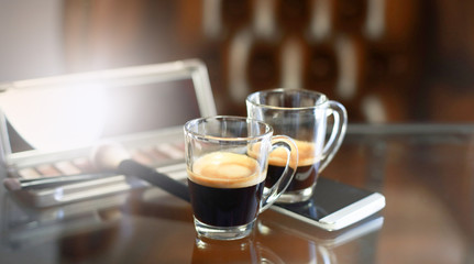 Cup of coffee with the phone and make-up set, shadow palette, and brushes