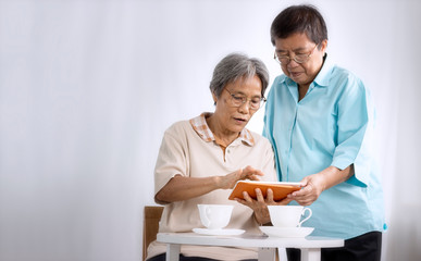 Love concept; Two senior women using tablet at home