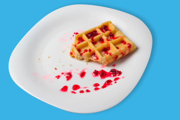 Belgian waffle with raspberry jam on a blue background. copy space