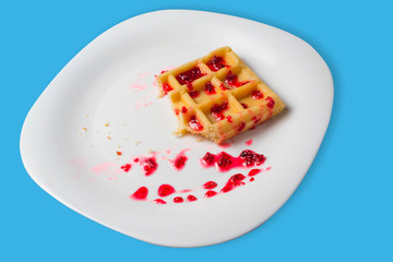 Belgian waffle with raspberry jam on a blue background. copy space