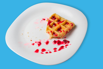 Belgian waffle with raspberry jam on a blue background. copy space