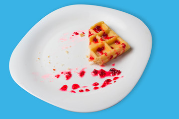 Belgian waffle with raspberry jam on a blue background. copy space