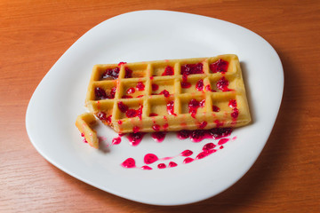 Belgian waffle with raspberry jam on a wooden background. copy space