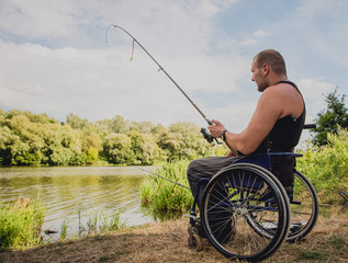 Handicapped man fishing at a lake. Wheelchair. Camping.