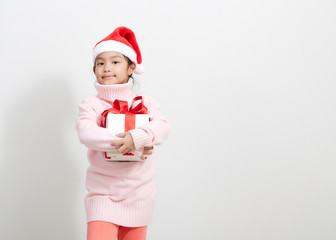 Girl holding a gift box in sweater and santa hat