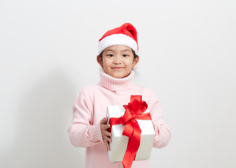 Girl holding a gift box in sweater and santa hat