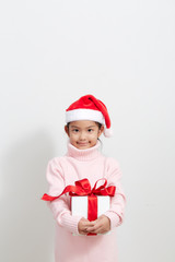 Girl holding a gift box in sweater and santa hat