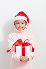 Girl holding a gift box in sweater and santa hat