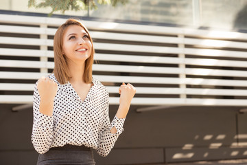 Happy business woman pumping fists celebrating success