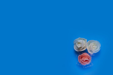 artificial flowers on a blue background frame for text. copy space