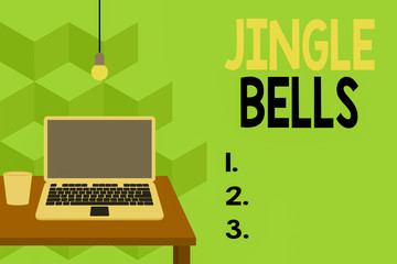 Text sign showing Jingle Bells. Business photo text Most famous traditional Christmas song all over the world Front view open laptop lying on wooden desktop light bulb falling glass