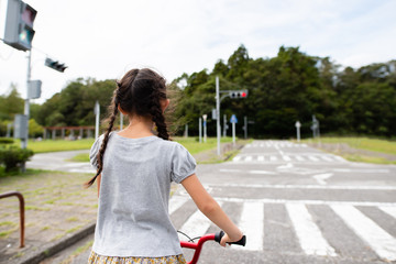 Fototapeta premium 赤信号で止まった自転車に乗った女の子